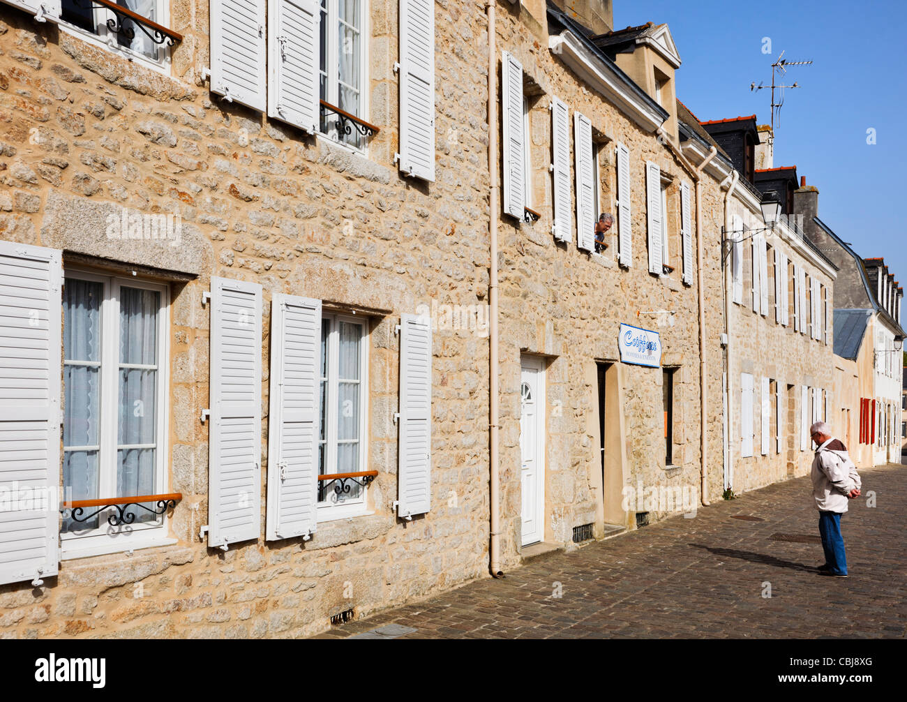 Morbihan, Bretagne, France - homme parlant à une femme dans une fenêtre dans la vieille ville de Port Louis Banque D'Images