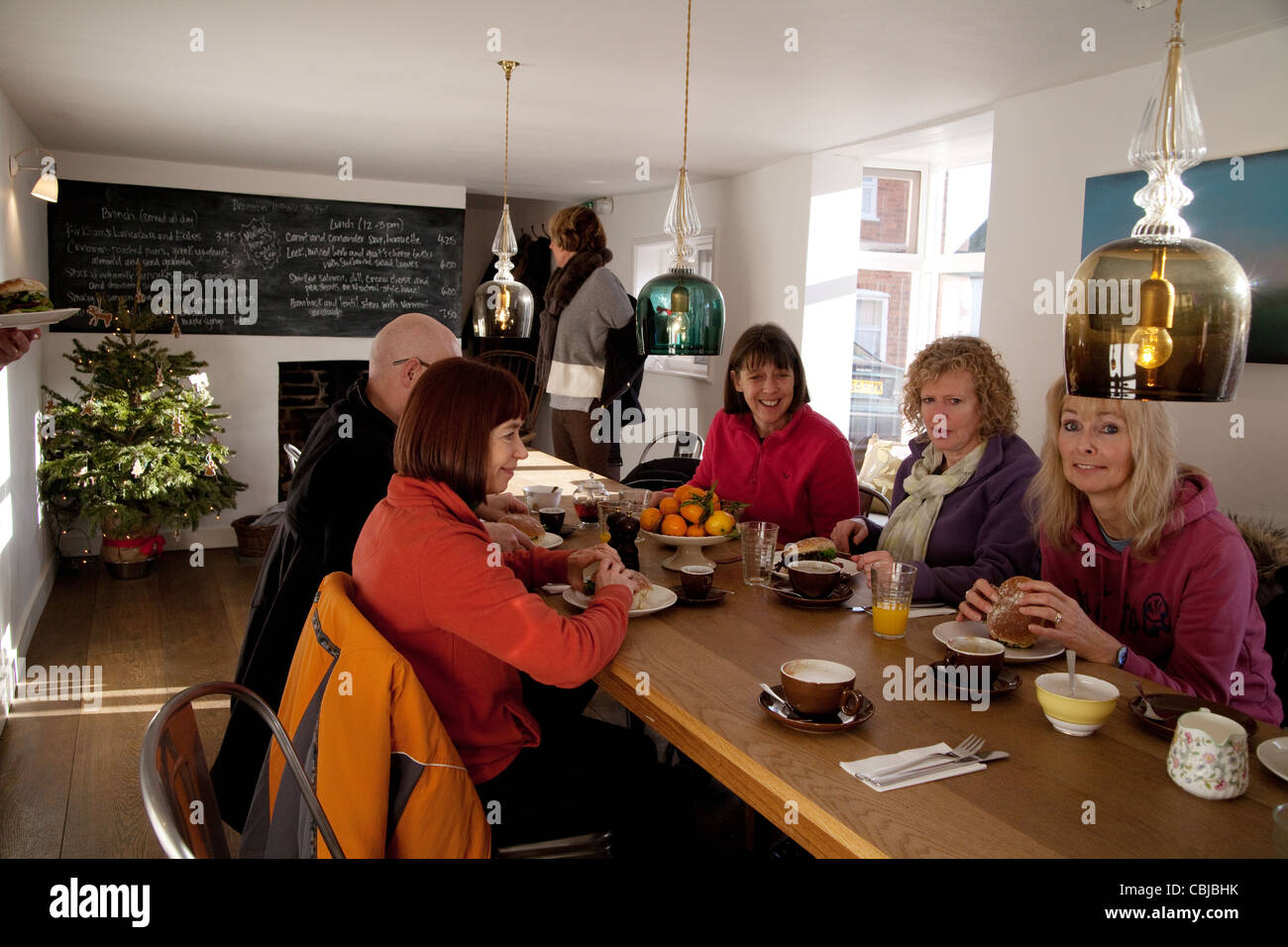 Un groupe de personnes d'âge moyen ayant le petit déjeuner, la boulangerie de la rue de la pompe, Village d'Orford, Suffolk UK Banque D'Images