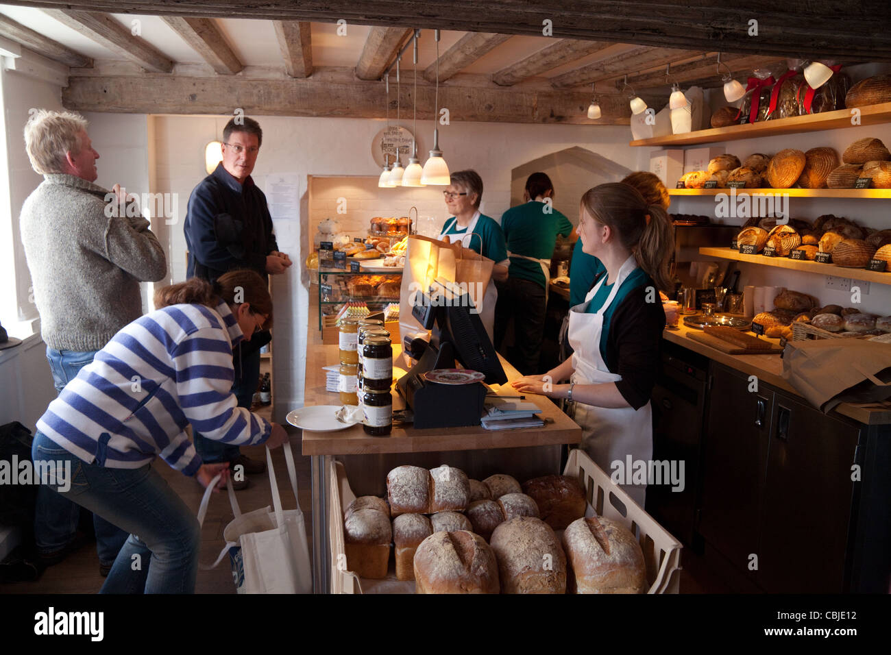 Les gens qui achètent le pain à la boulangerie de la rue de la pompe, Orford Village Suffolk UK Banque D'Images