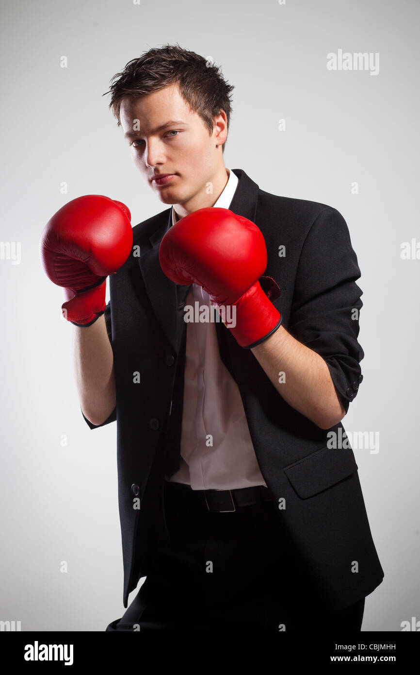 Businessman Wearing Boxing gloves, sur fond gris Banque D'Images