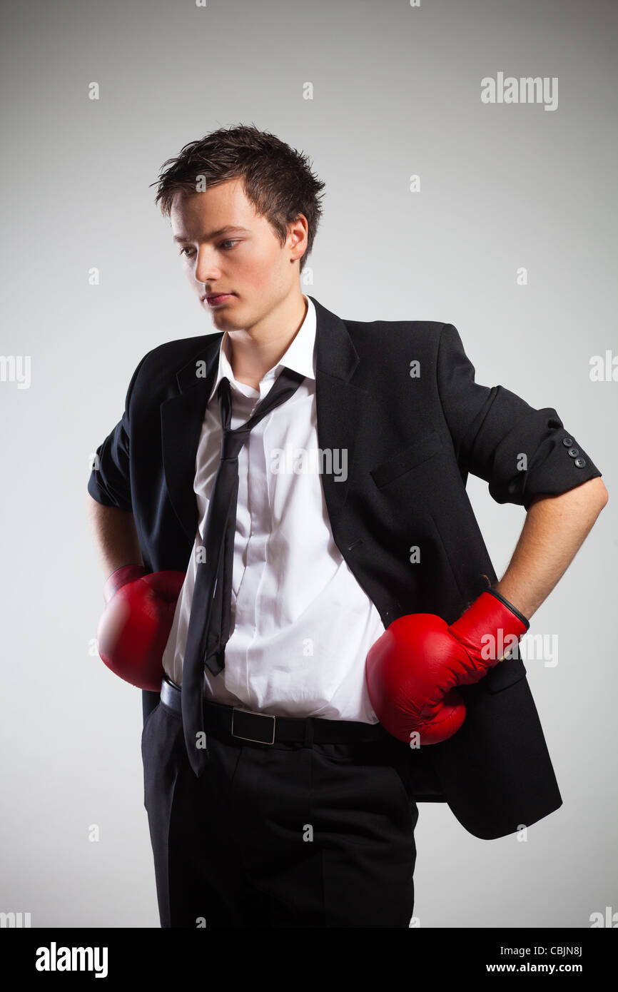 Businessman Wearing Boxing gloves, sur fond gris Banque D'Images