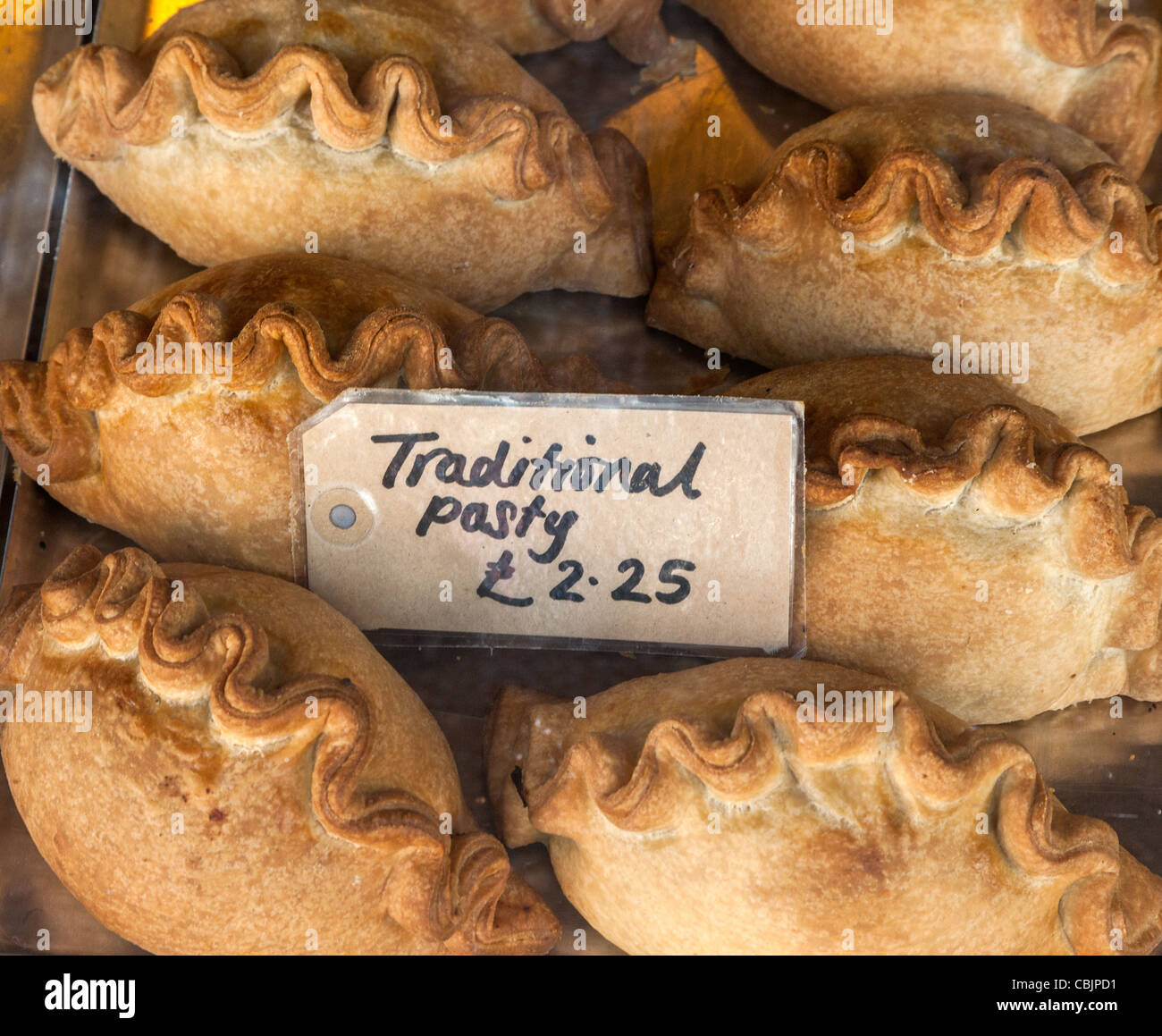 Pasties en vente dans une boulangerie avec panneau disant €2,25 traditionnel pasty, Cornwall, Angleterre. Banque D'Images
