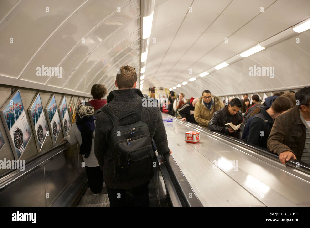 Les passagers et les usagers sur l'escalier mécanique à la station de métro de Londres Angleterre Royaume-Uni uk Banque D'Images
