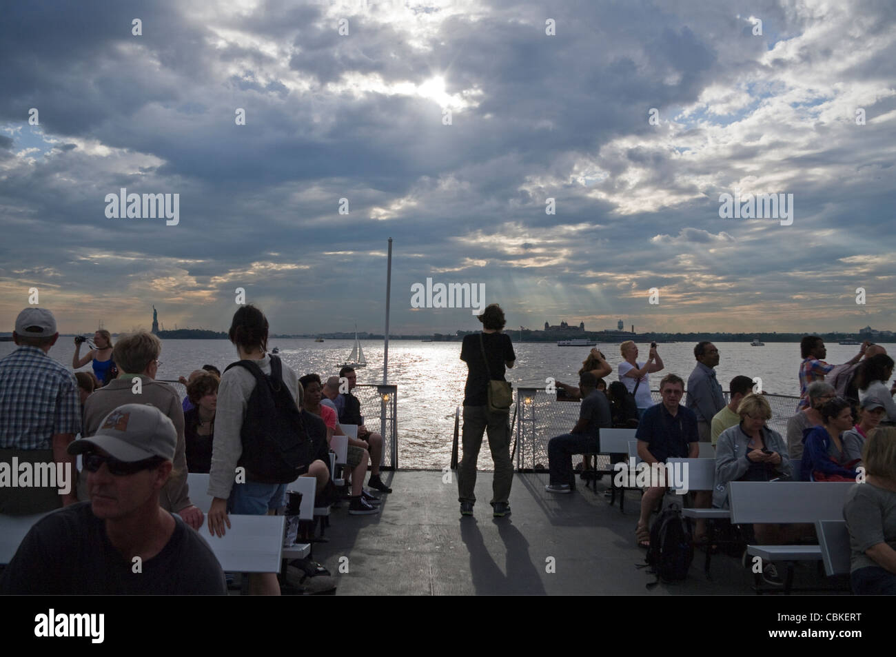 Ferry Statue de la Liberté et Ellis Island (en arrière-plan) les touristes sur le pont du bateau de retour à Manhattan après visite. Banque D'Images