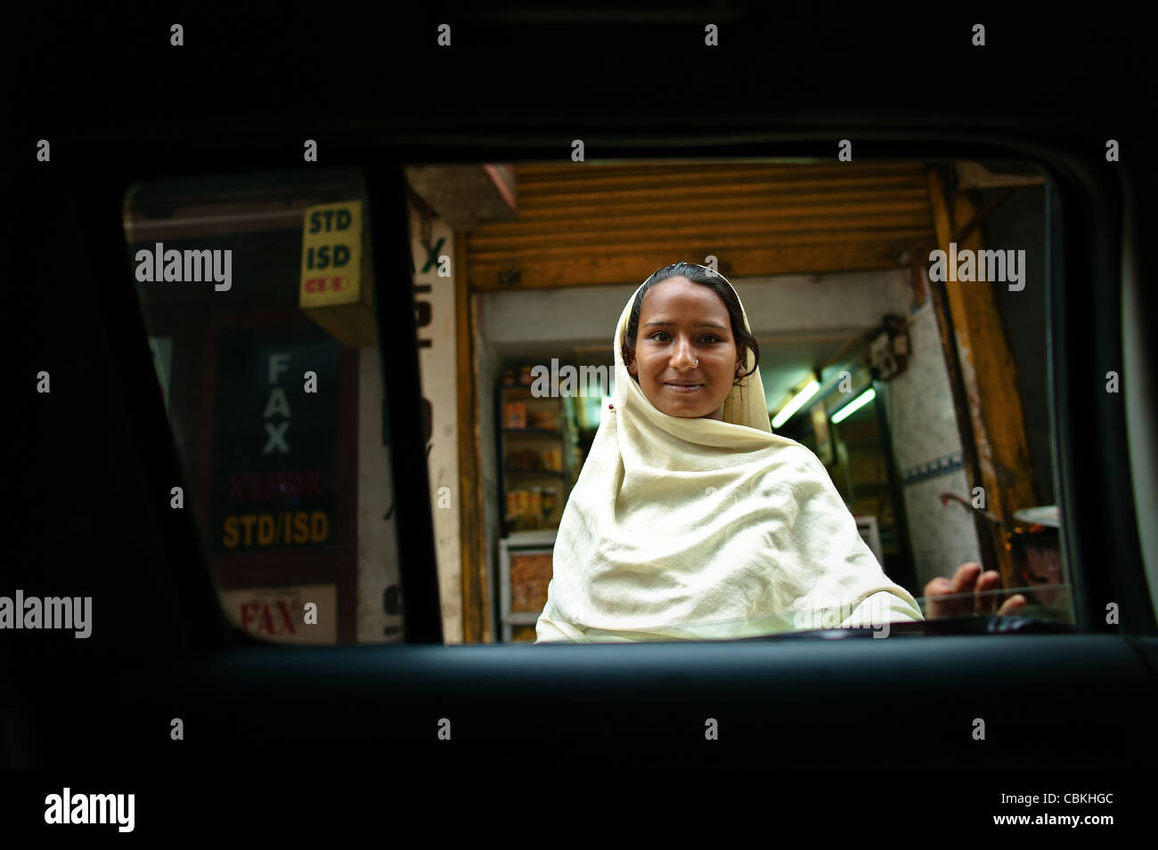 D'Œil indien, mendiant à la fenêtre d'un taxi pour le sou à New Delhi en Inde. Banque D'Images