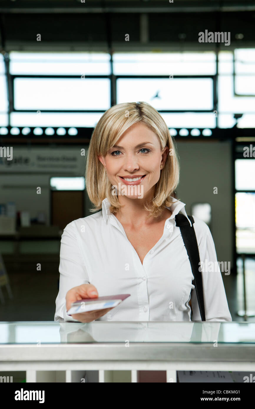 Femme avec les billets d'avion à l'arrivée dans le bureau de l'aéroport Banque D'Images