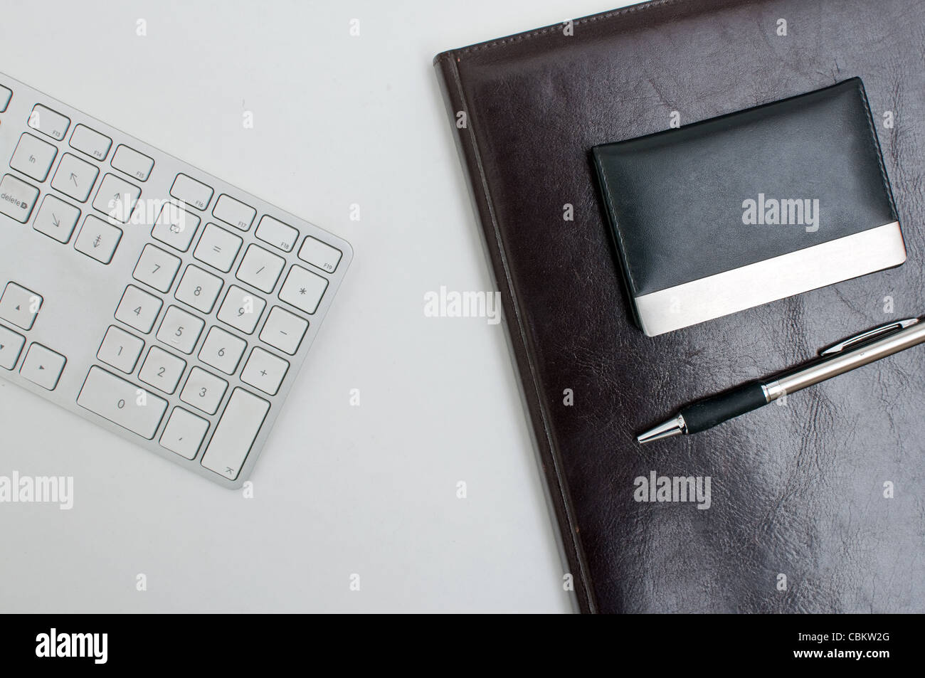 Détail de bureau, un clavier d'ordinateur, de l'ordre du jour et d'un stylo sur une table blanche. Concept d'entreprise. Banque D'Images