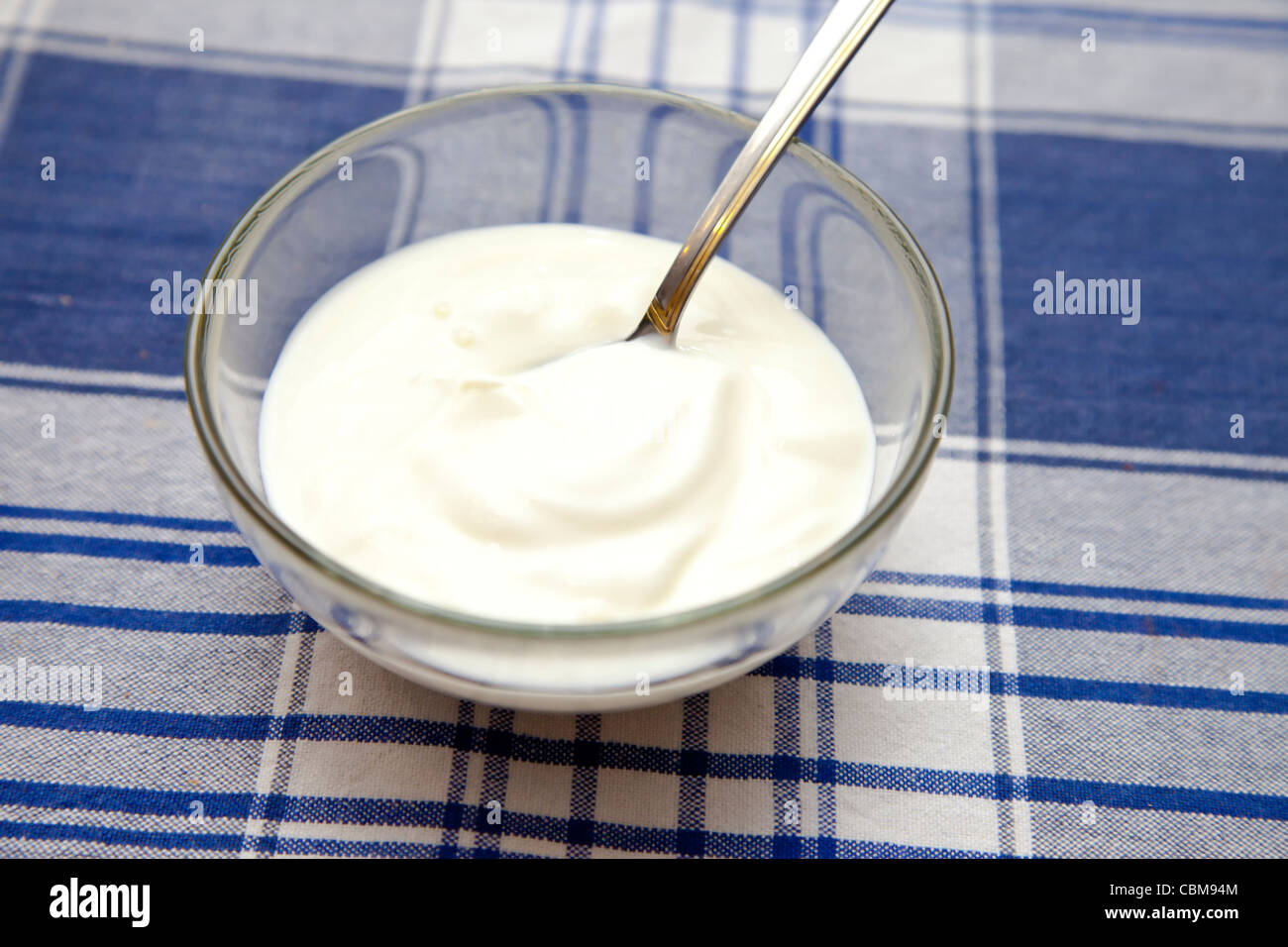 Le yogourt dans un bol avec une cuillère sur la table Banque D'Images