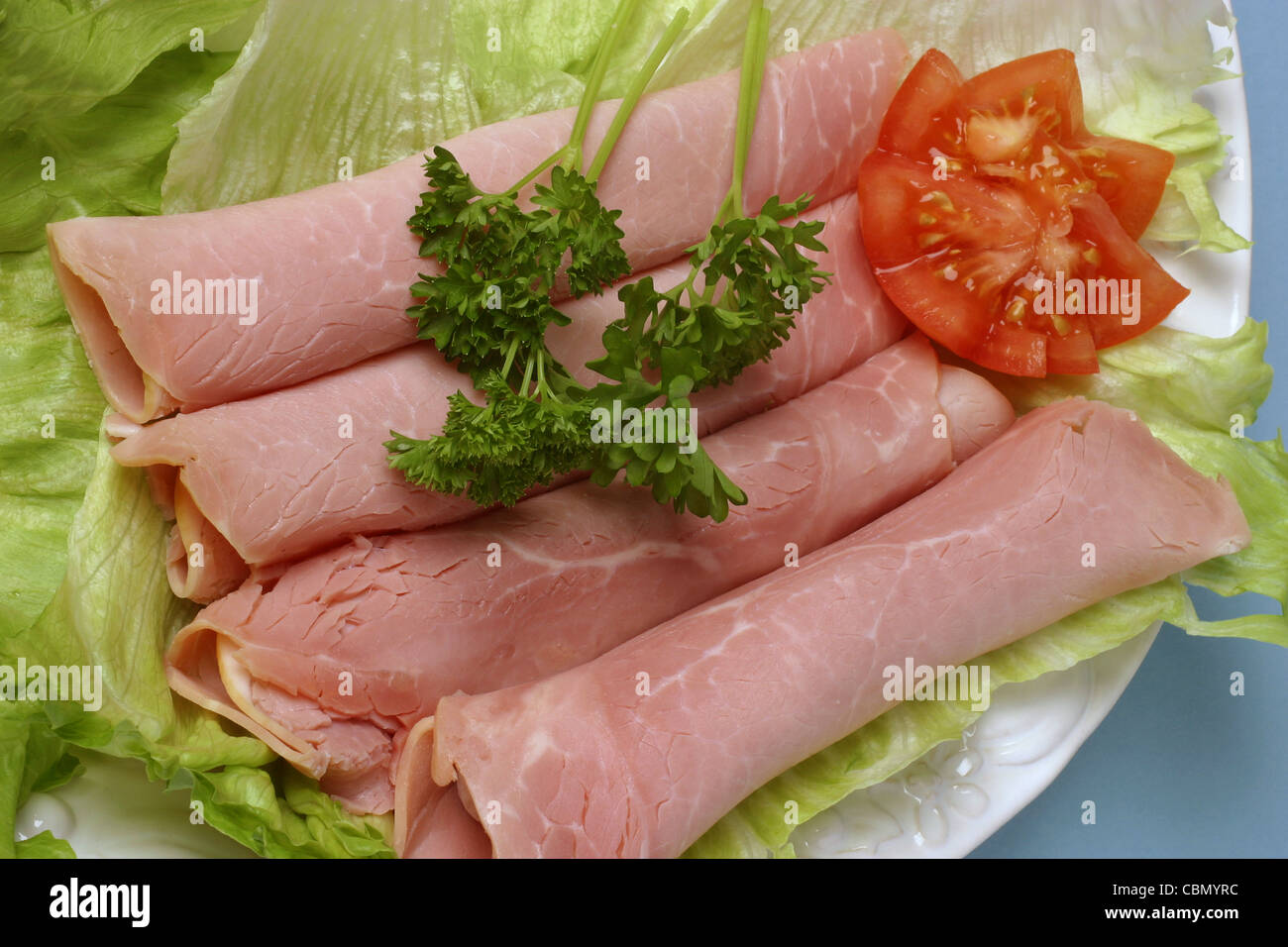 Tranches de jambon sur un lit de laitue Banque D'Images