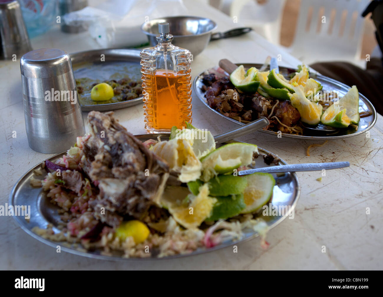 Les restes d'un repas de viande en plaque argentée sur une table dans un restaurant. Banque D'Images