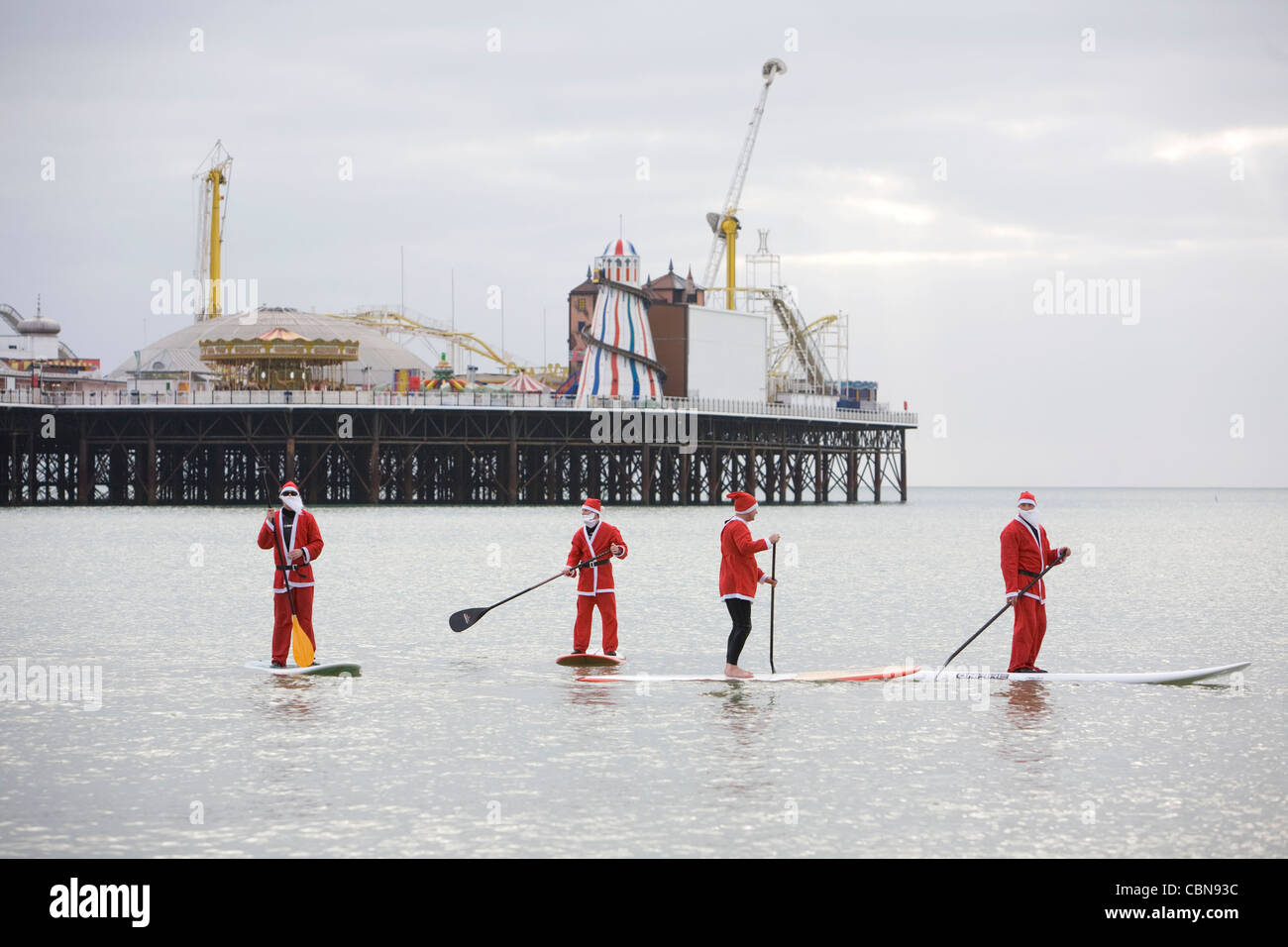 Jour de Noël Paddle boarders déguise en père Noël à Brighton. Photo par James Boardman. Banque D'Images