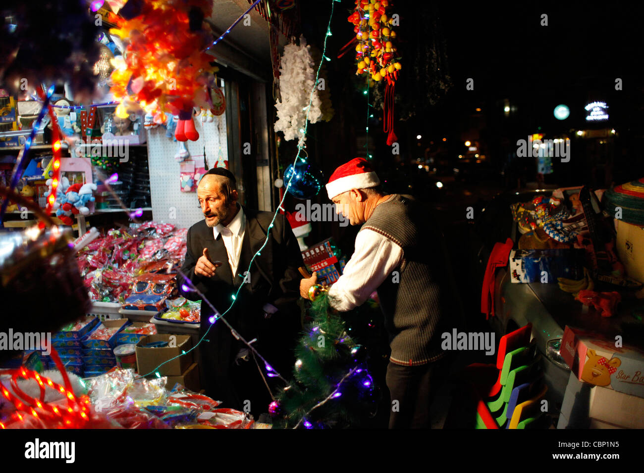 Un homme juif orthodoxe religieux dans un magasin vendant des décorations de Noël à Tel Aviv ISRAËL Banque D'Images