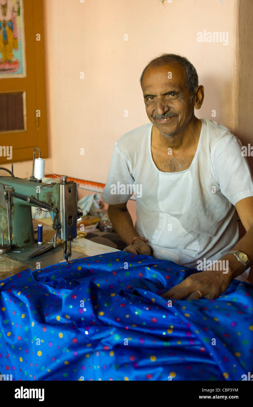 Tailleur indien utilise machine à coudre pour faire des vêtements en soie à Narlai village de Rajasthan, Inde Banque D'Images