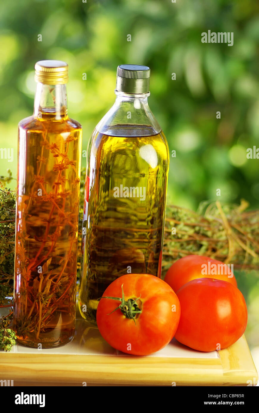 L'huile d'olive, le vinaigre, l'origan et les tomates. Banque D'Images