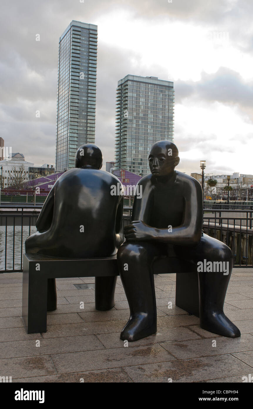 Deux hommes sur un banc de la sculpture à Cubitt comme suit par le sculpteur Giles Penny Canary Wharf, Isle of Dogs. Banque D'Images