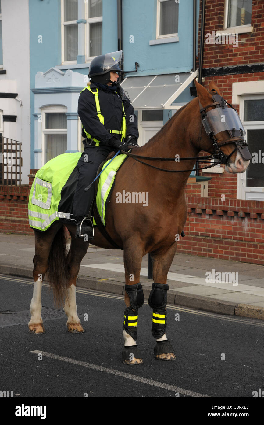 Un officier de la police montée et l'émeute de protection en robe au cours d'un match de football de contrôle de foule. Portsmouth Hampshire. Banque D'Images