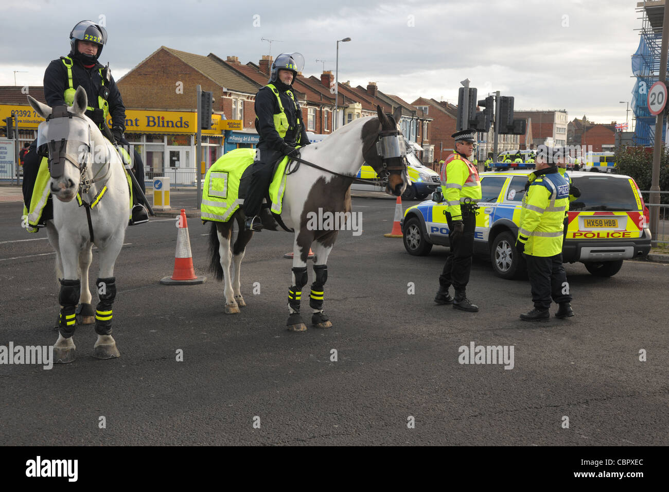 Les officiers montés et pied bloc police un important carrefour au cours d'un match de football de contrôle de foule. Portsmouth Hampshire. Banque D'Images