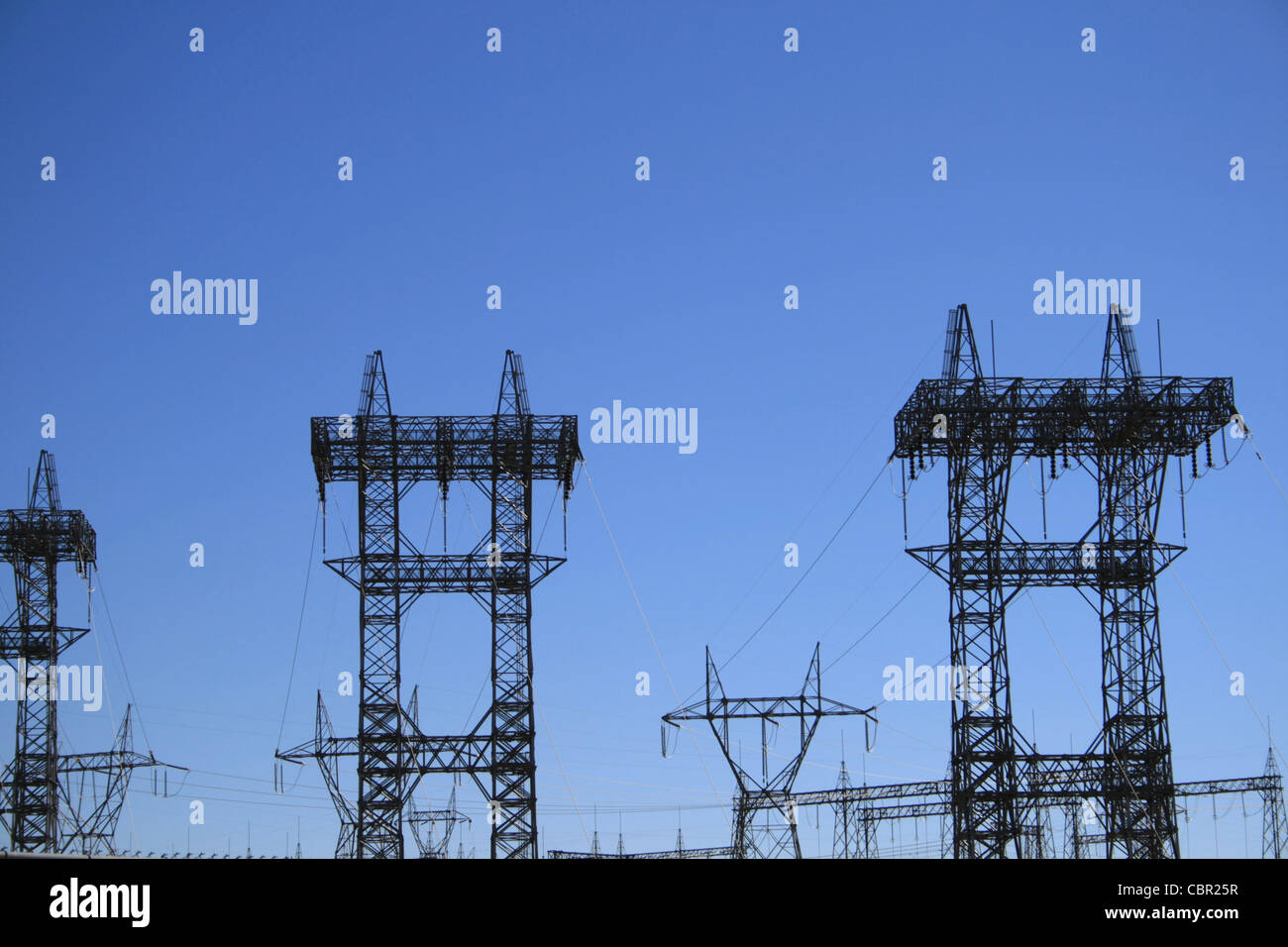 Les pylônes électriques haute tension et les lignes against a blue sky Banque D'Images