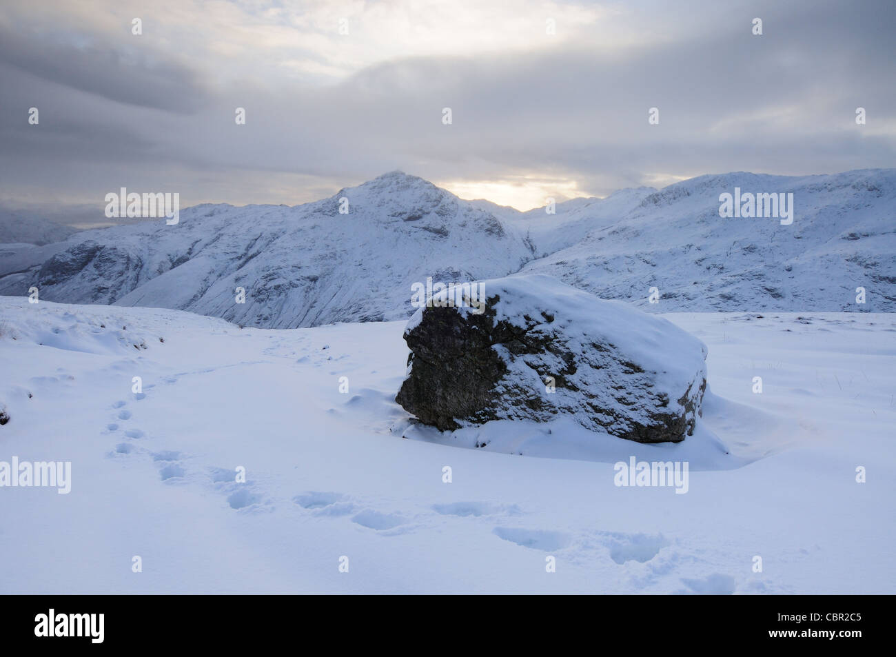 Des traces de pas dans la neige sur la bande sur Bowfell dans le Lake District, avec Pike O Blisco en arrière-plan Banque D'Images