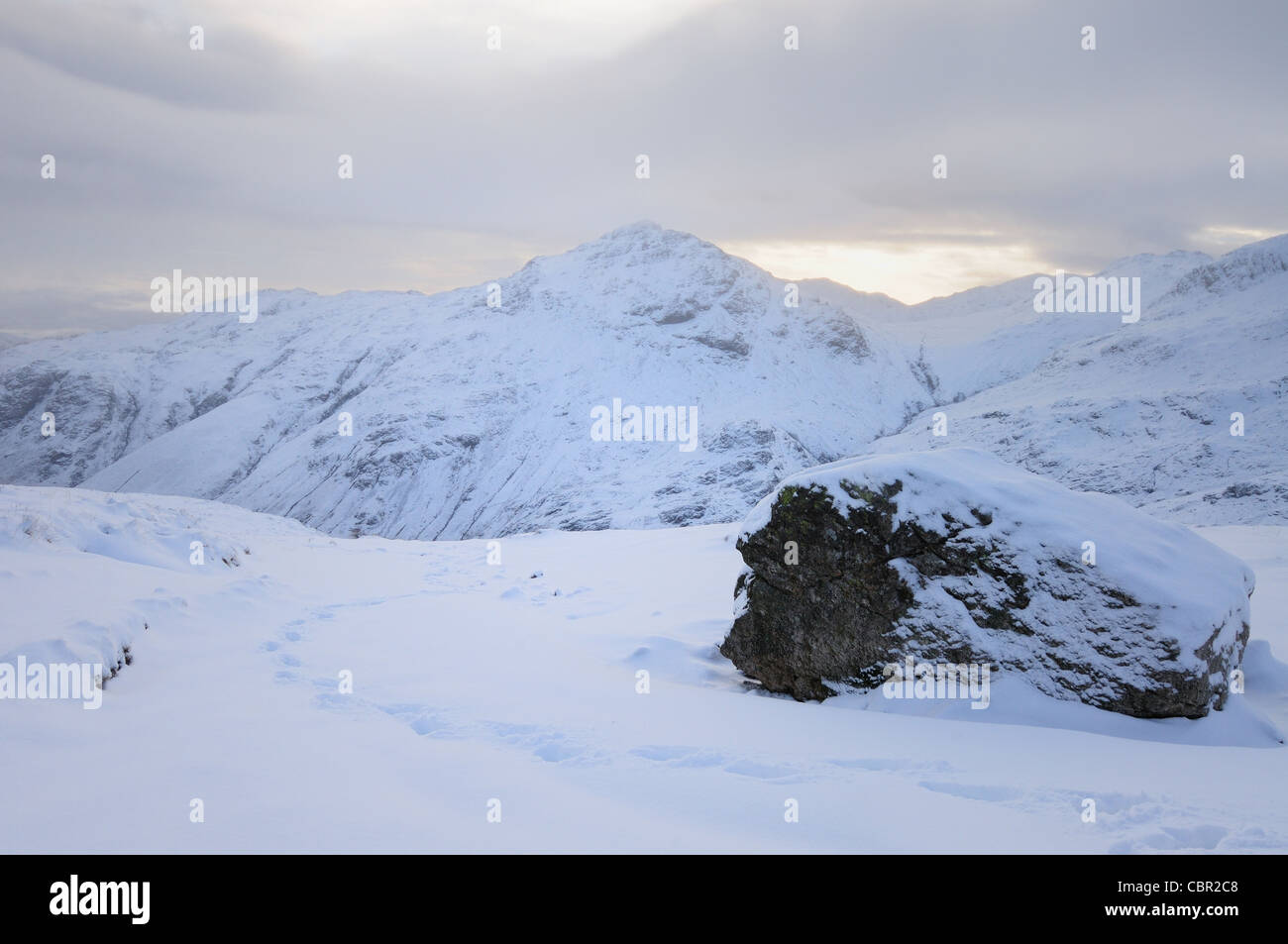 Des traces de pas dans la neige sur la bande sur Bowfell dans le Lake District, avec Pike O Blisco en arrière-plan Banque D'Images