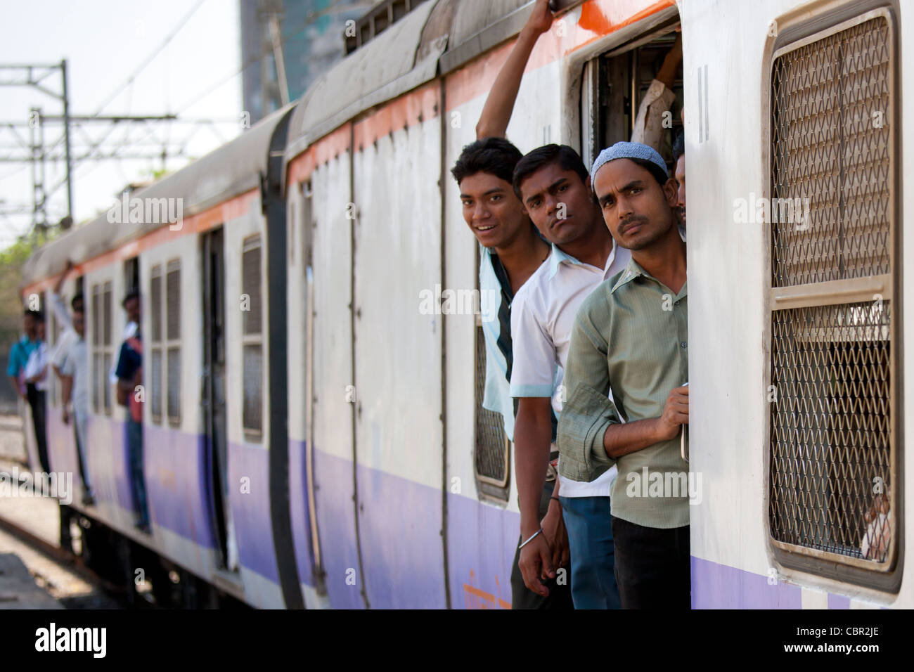 Travailleurs sur les trains de banlieue bondés de la gare ferroviaire de l'Ouest près de Mahalaxmi Mumbai sur le rer, Inde Banque D'Images