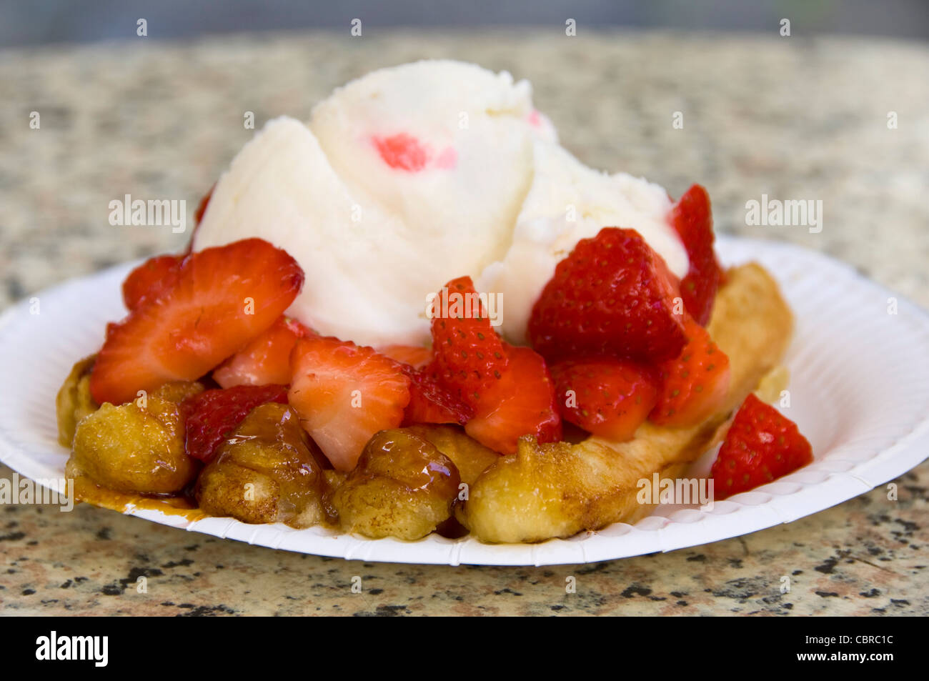 Close up of a horizontal préparés gaufre de Liège étouffés dans les fraises fraîches et de crème caillée. Banque D'Images