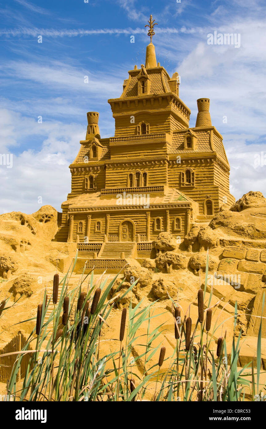 Close up vertical d'une incroyable sculpture de sable d'une immense maison au soleil. Banque D'Images