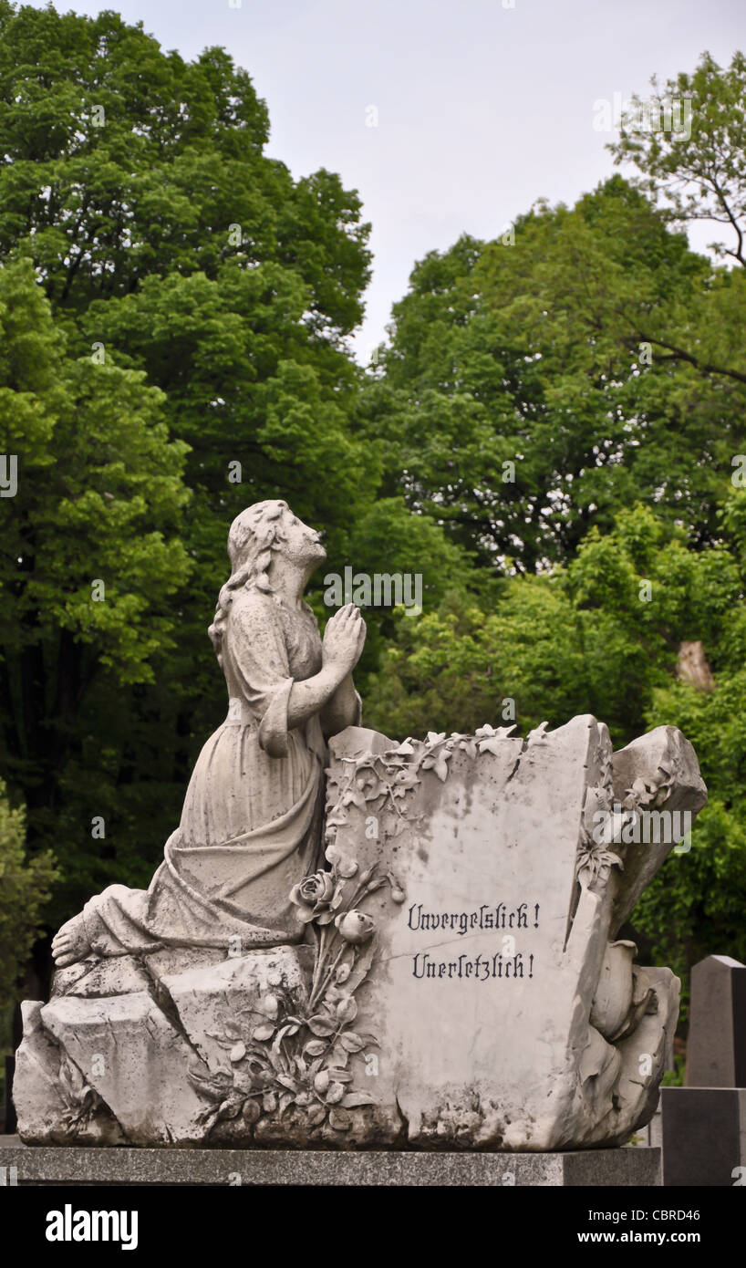 Statue de femme à genoux sur une pierre tombale avec les mots 'inoubliable' et 'irremplaçable' Banque D'Images