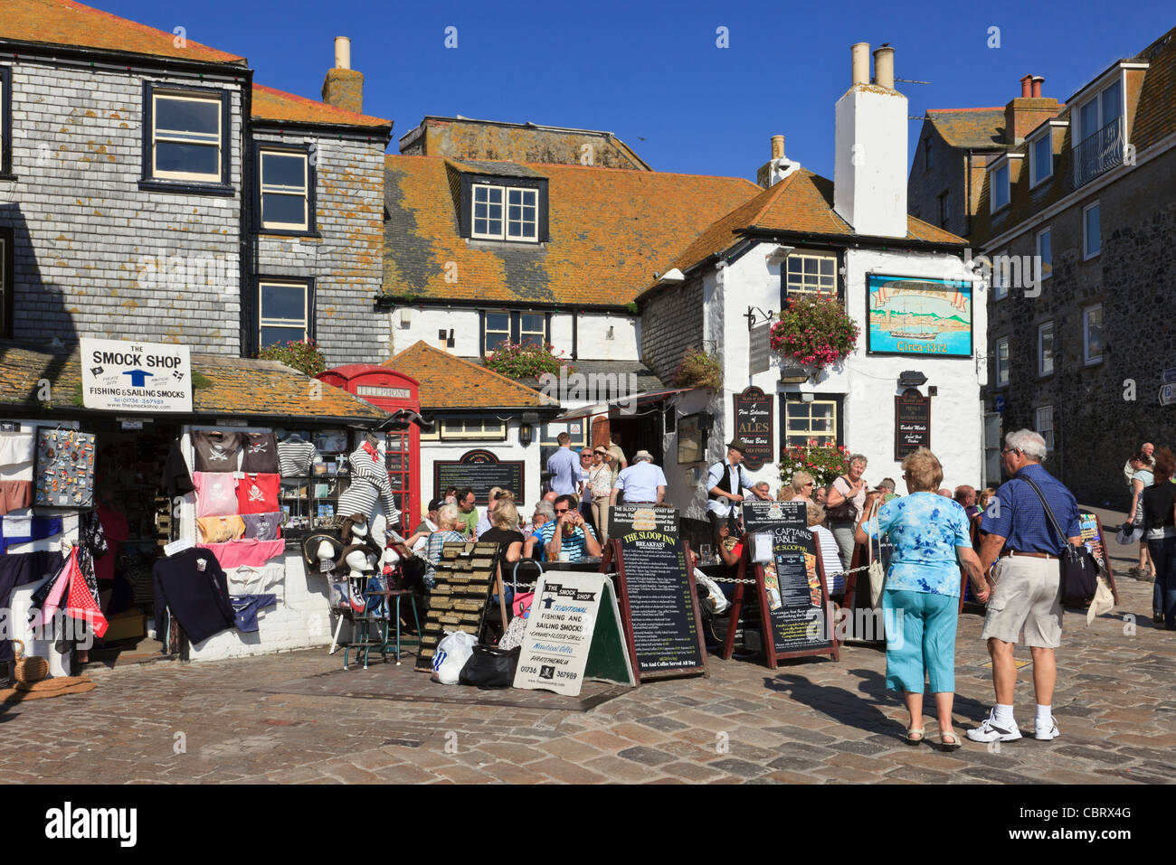 Le Sloop Inn traditionnel pub du XIVe siècle est animé par les visiteurs qui s'assècent dehors dans un café en plein air. St Ives, Cornouailles, Angleterre, Royaume-Uni, Grande-Bretagne Banque D'Images
