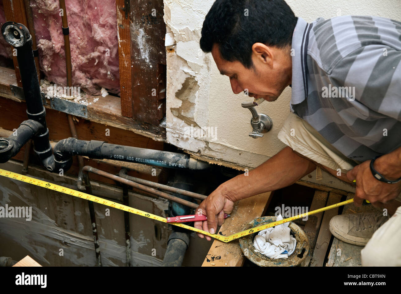 Homme hispanique du Mexique travailler sa propre entreprise de construction aux Etats-Unis à l'étage douche remplace. M. © Myrleen Pearson Banque D'Images