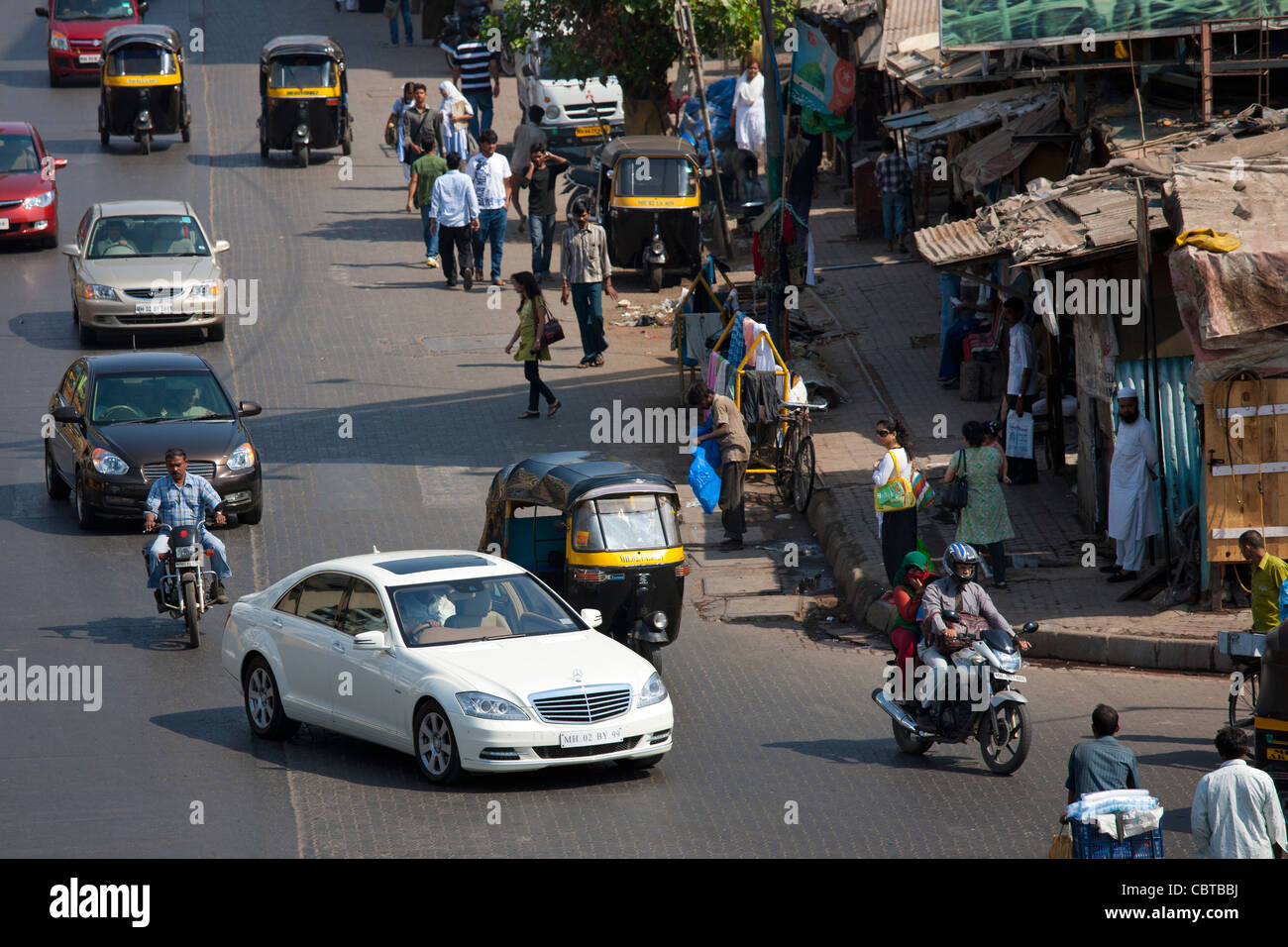 Mercedes Classe S Berline de Luxe et auto rickshaws entre dans la circulation près de Bandra complexe BKC dans Mumbai, Inde Banque D'Images