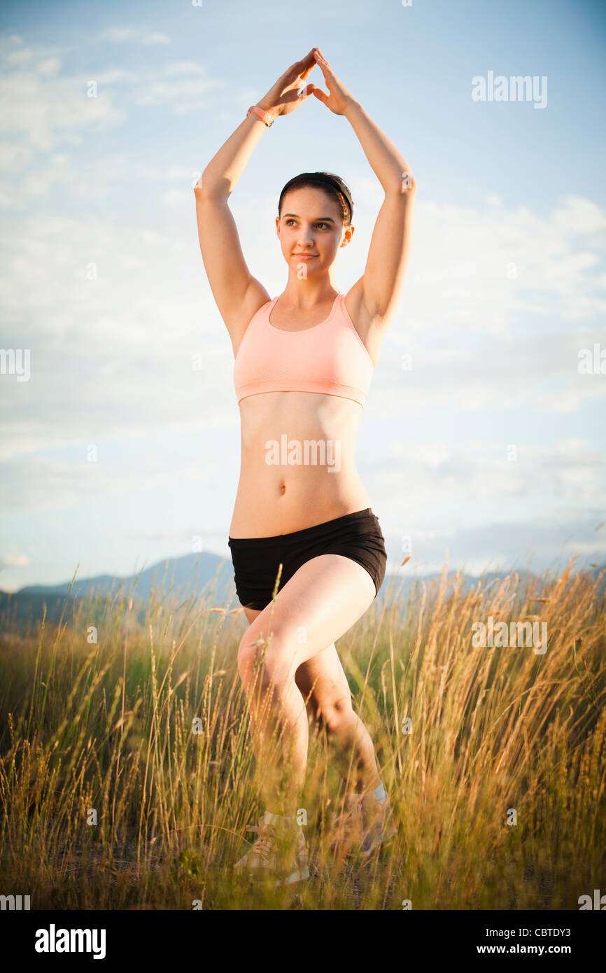 Caucasian woman exercising in field Banque D'Images
