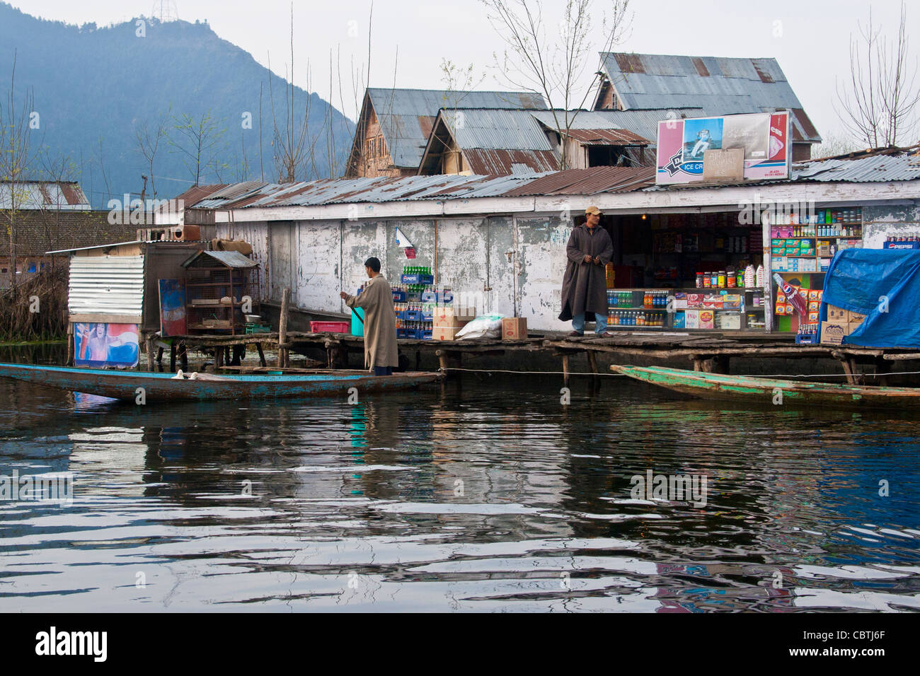Village typique de Kashmiri dans le lac Nagin de Srinagar, Cachemire, Inde, avec maisons traditionnelles, maisons flottantes, bateaux de campagne et villageois. Banque D'Images