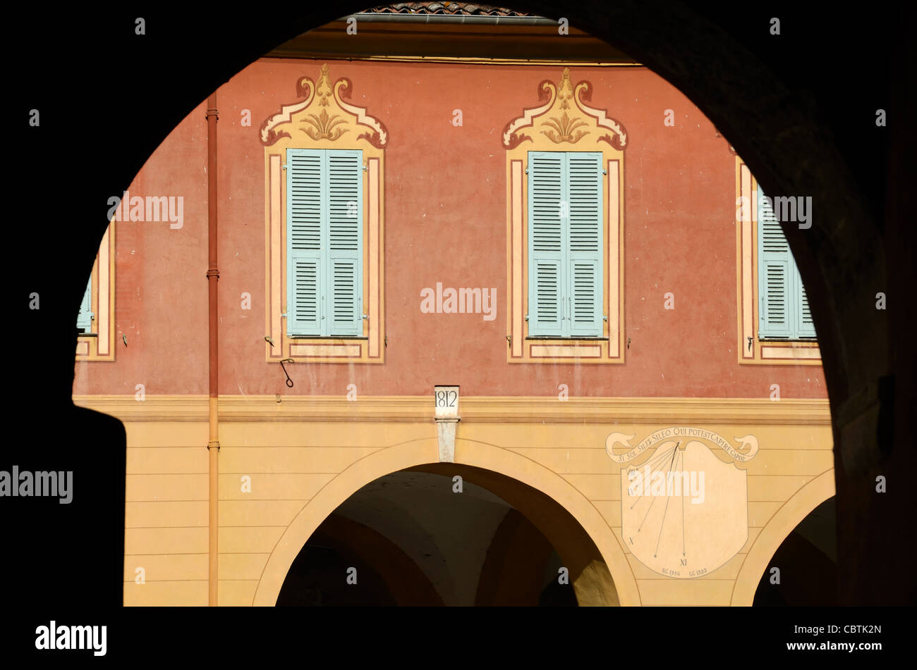 Façade baroque avec encadrement de la fenêtre de Tompe-l'oeil, volets, cadran solaire et arcades Sospel Alpes-Maritimes France Banque D'Images