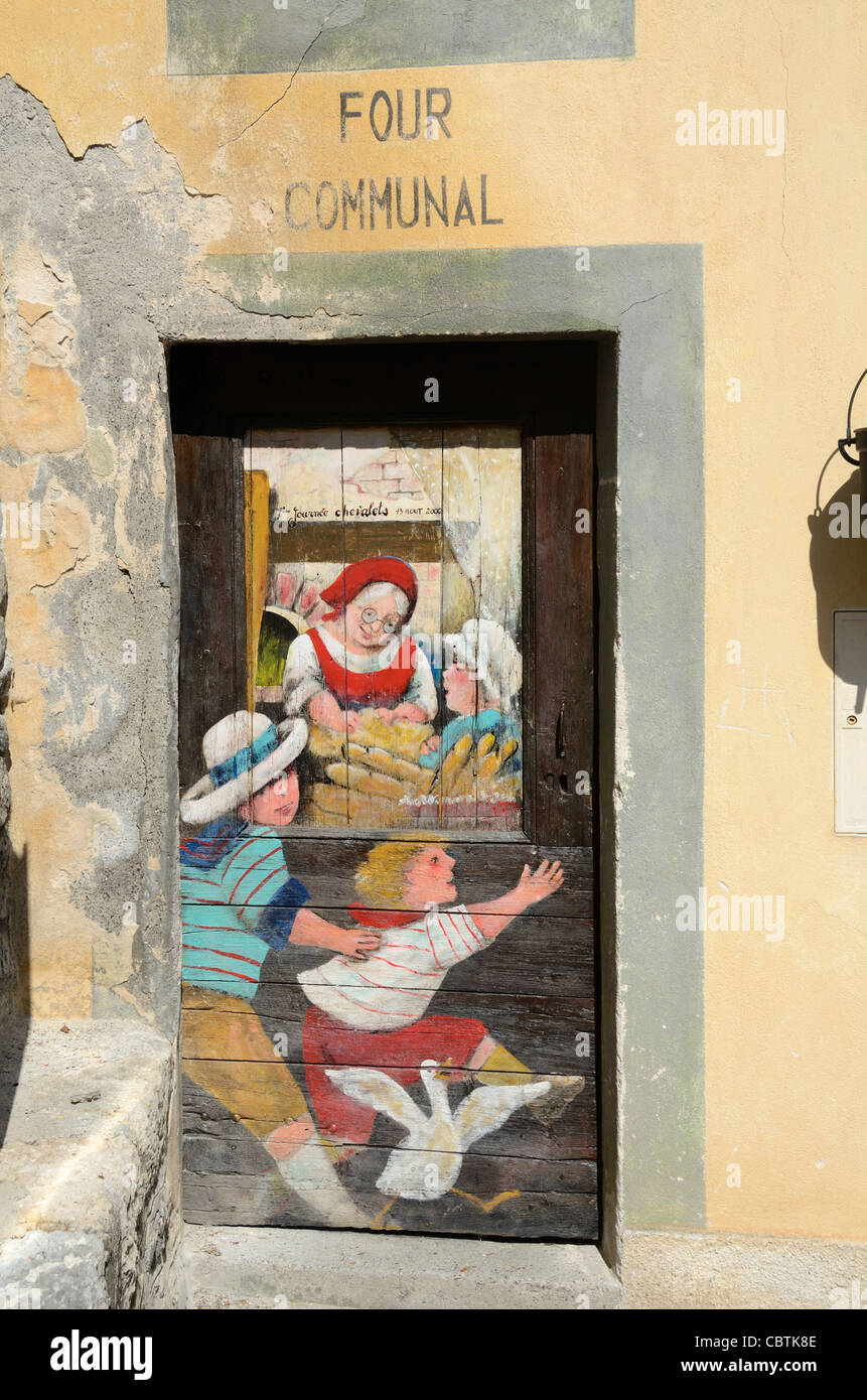 Porte peinte sur le four communal ('four communal') montrant la scène enfants et cuisine domestique, Roubion Alpes-Maritimes France Banque D'Images