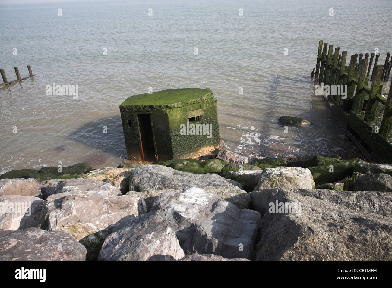 Vieux comprimé fort tombé dans la mer. L'érosion côtière et les défenses maritimes endommagées à East Lane, Bawdsey, Suffolk, Angleterre Banque D'Images