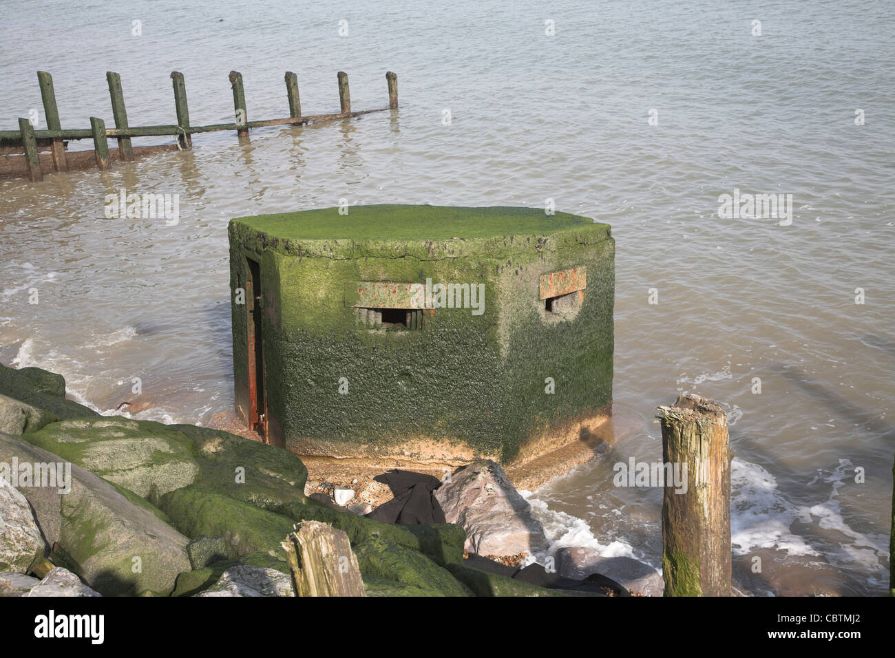 Vieux comprimé fort tombé dans la mer. L'érosion côtière et les défenses maritimes endommagées à East Lane, Bawdsey, Suffolk, Angleterre Banque D'Images