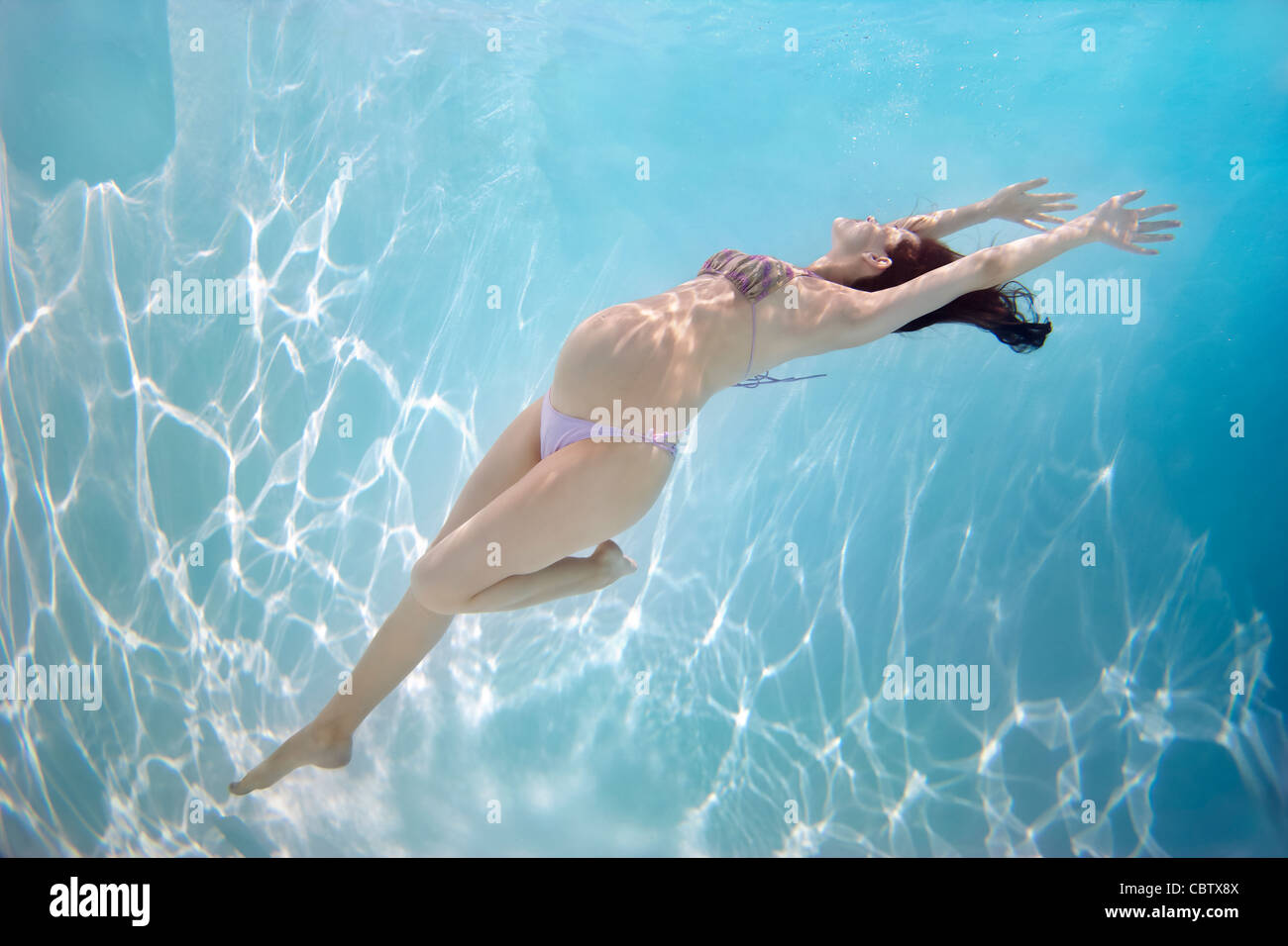 Pregnant Caucasian woman swimming underwater Banque D'Images