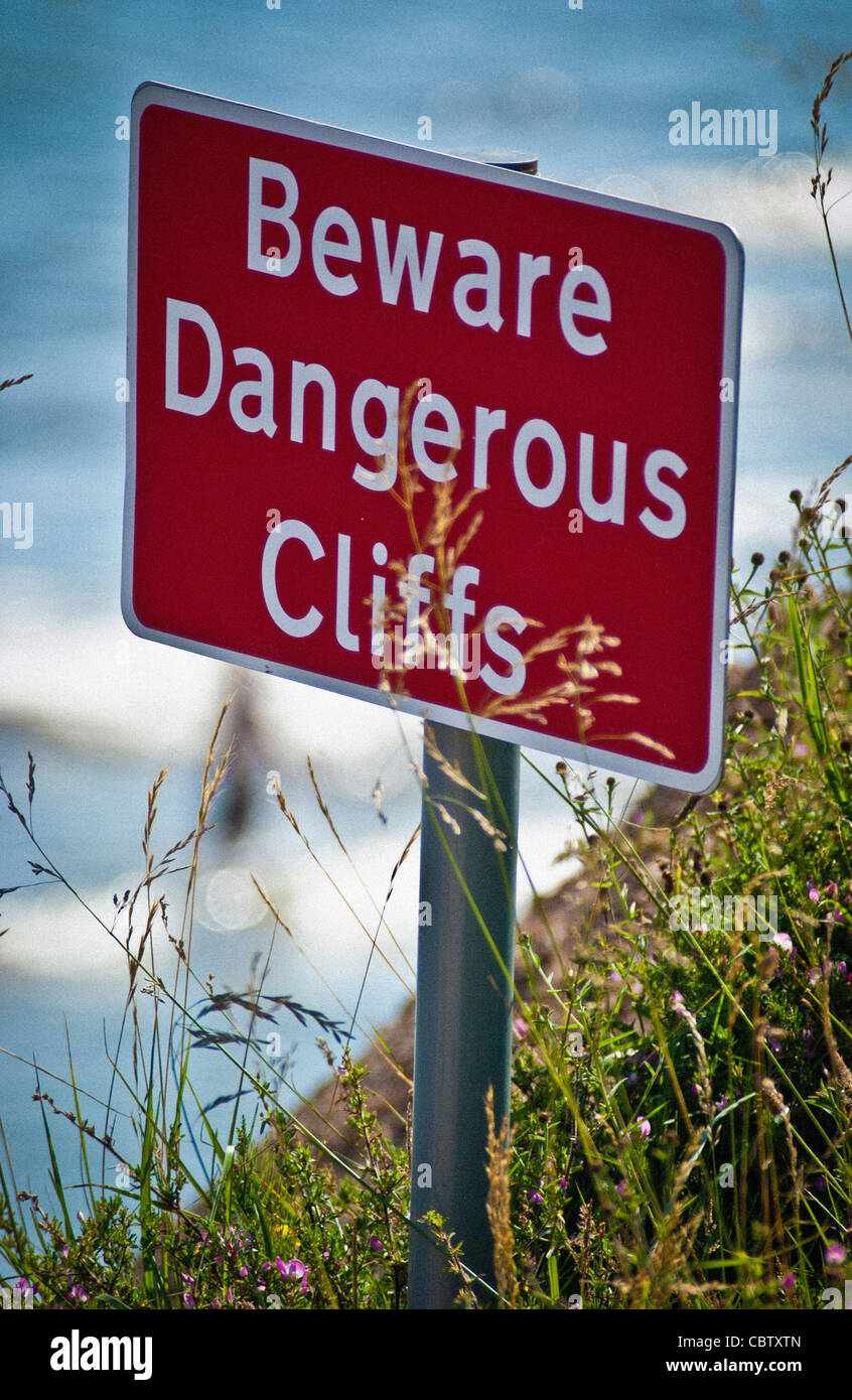 Méfiez-vous du panneau danger Cliffs au bord d'une falaise abrupte avec la mer en dessous Banque D'Images
