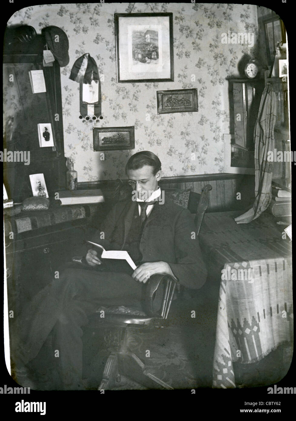 Vers 1900 Vue d'un homme dans son salon de style victorien ou d'étude. Banque D'Images
