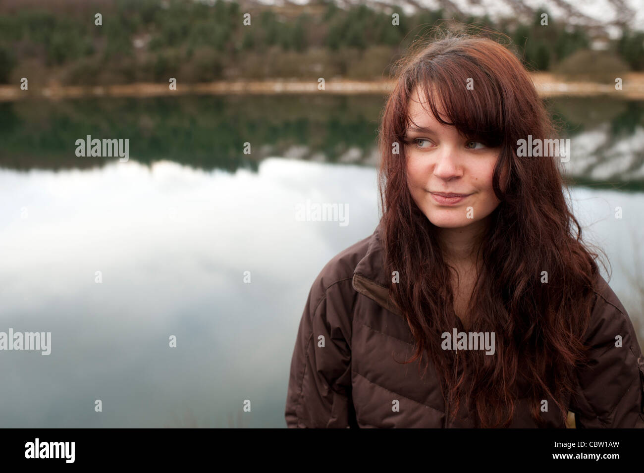 A 16 ans, adolescente brune à l'extérieur, par un après-midi d'hiver, lac, UK Banque D'Images