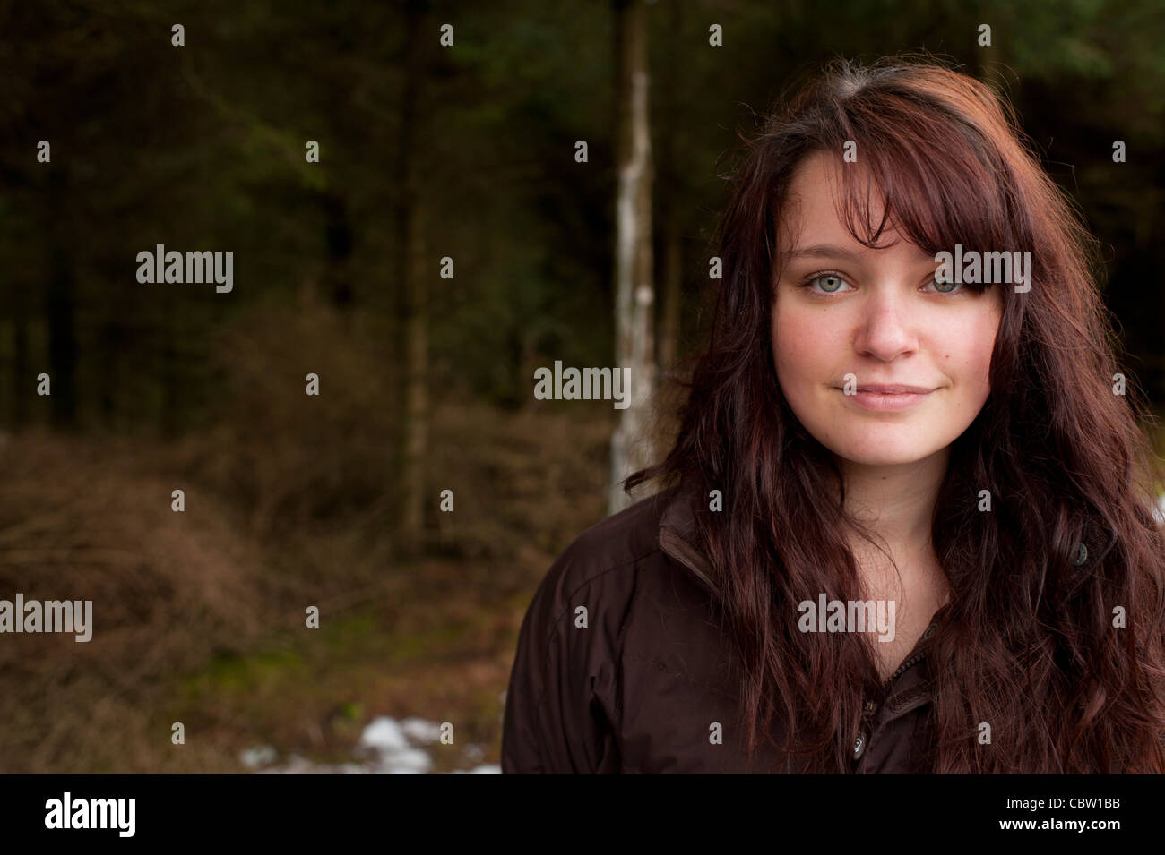 A 16 ans, adolescente aux cheveux brun aux yeux verts, à l'extérieur, après-midi d'hiver, UK Banque D'Images