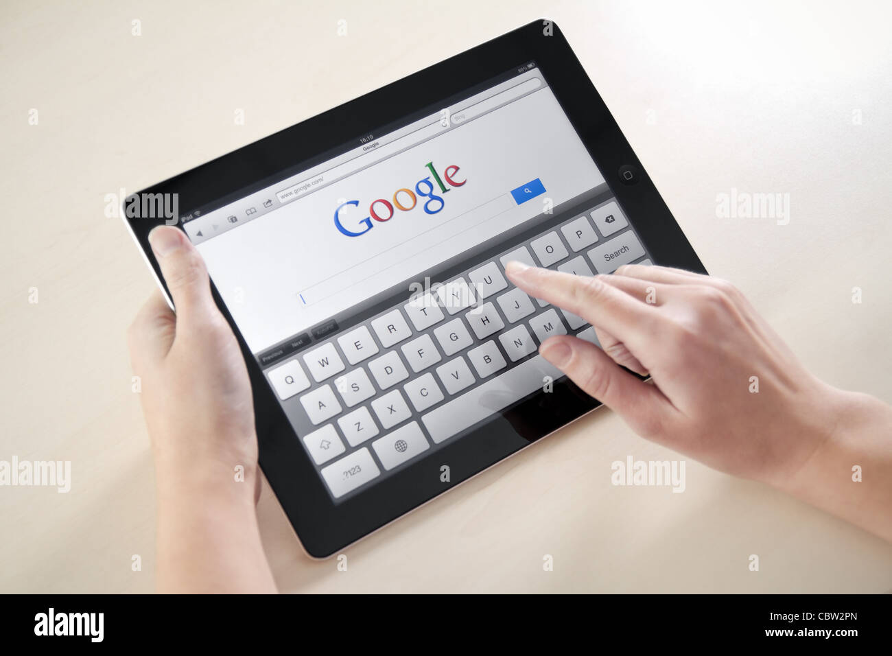 Femme mains tenant et toucher sur Apple iPad2 avec Google search page web sur un écran. Banque D'Images