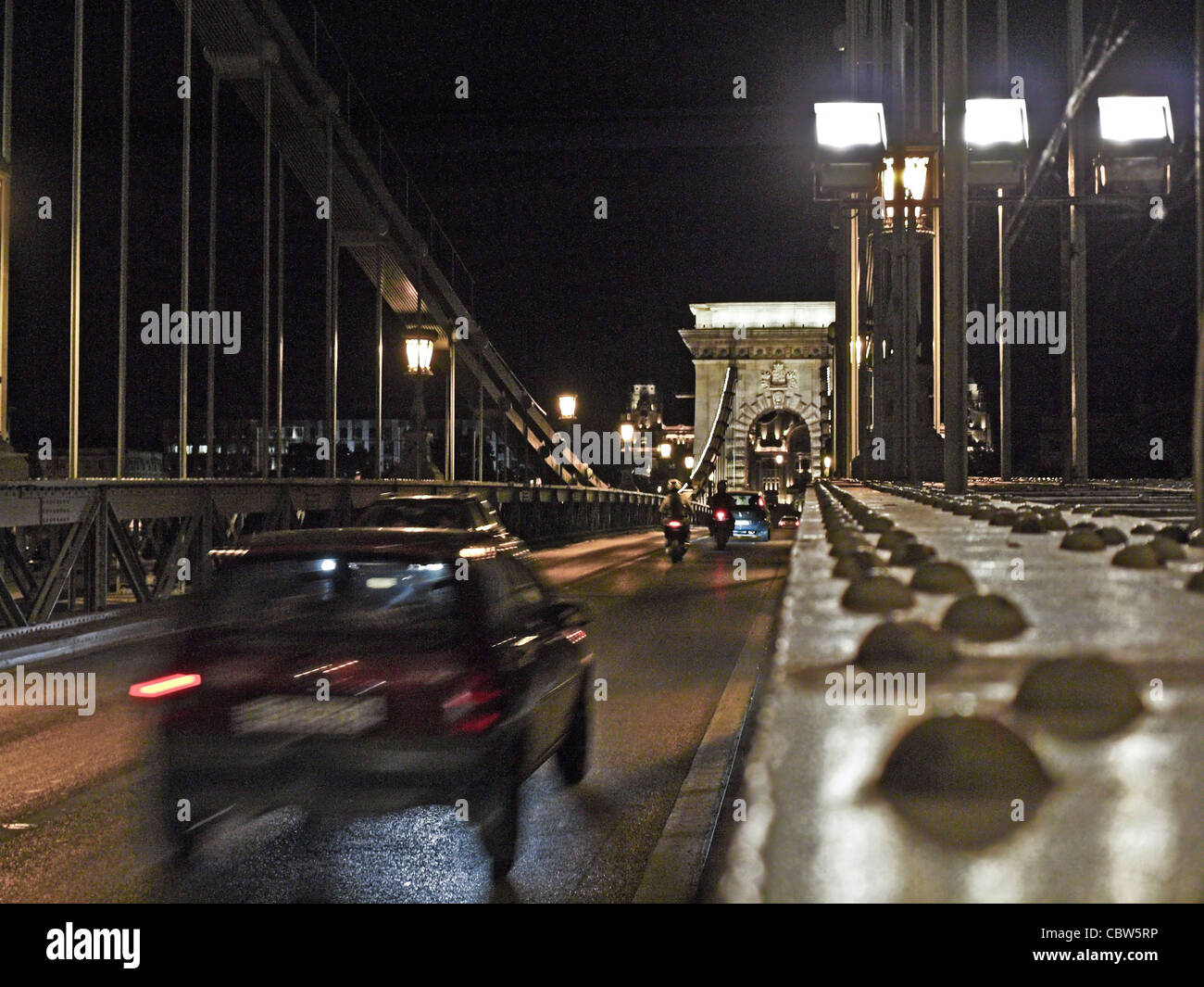 Véhicules traversant le Pont des Chaînes dans la nuit. Budapest, Hongrie Banque D'Images