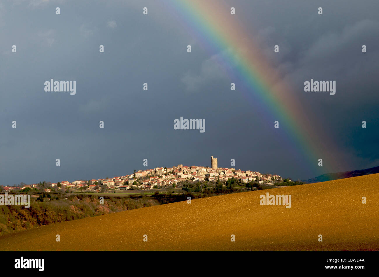 Arc-en-ciel sur le paysage et le village de Montpeyroux, Auvergne, France Banque D'Images