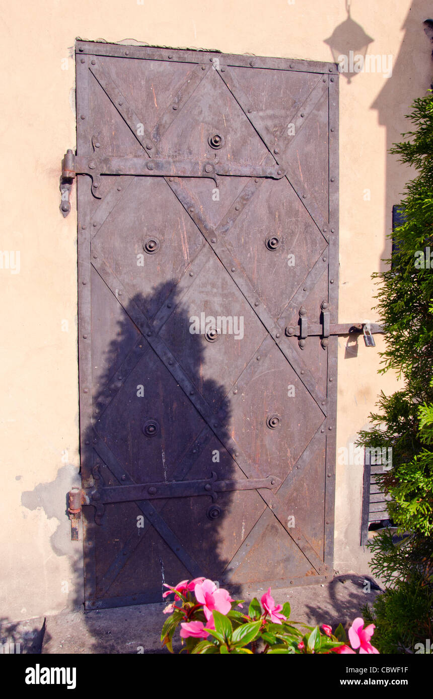 L'ancienne porte métallique avec cadenas fermé l'ornement. La solution architecturale. Banque D'Images