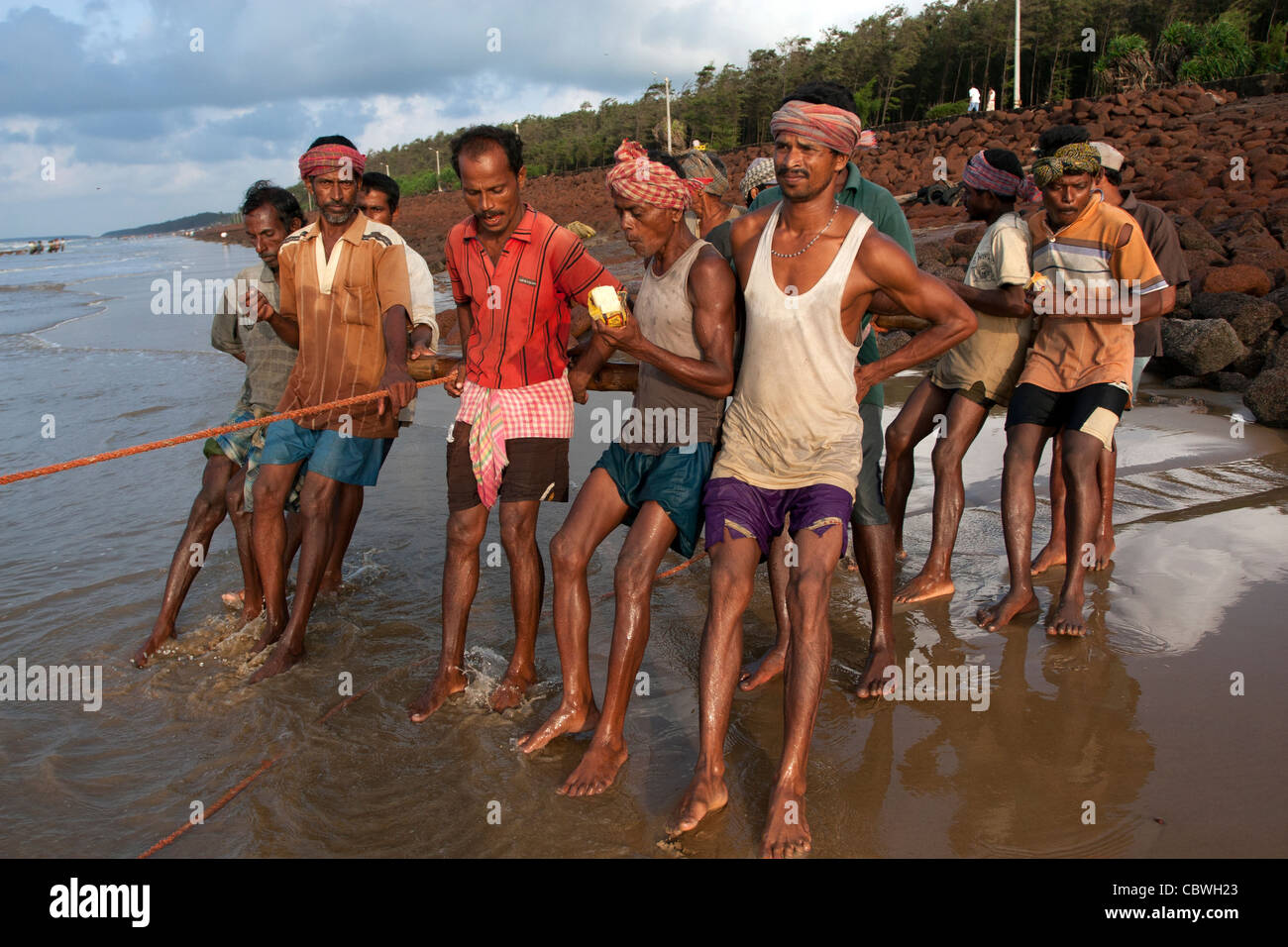 Filet de pêche Les pêcheurs l'arraché ensemble dans la plage de Digha, Bengale occidental, Inde Banque D'Images