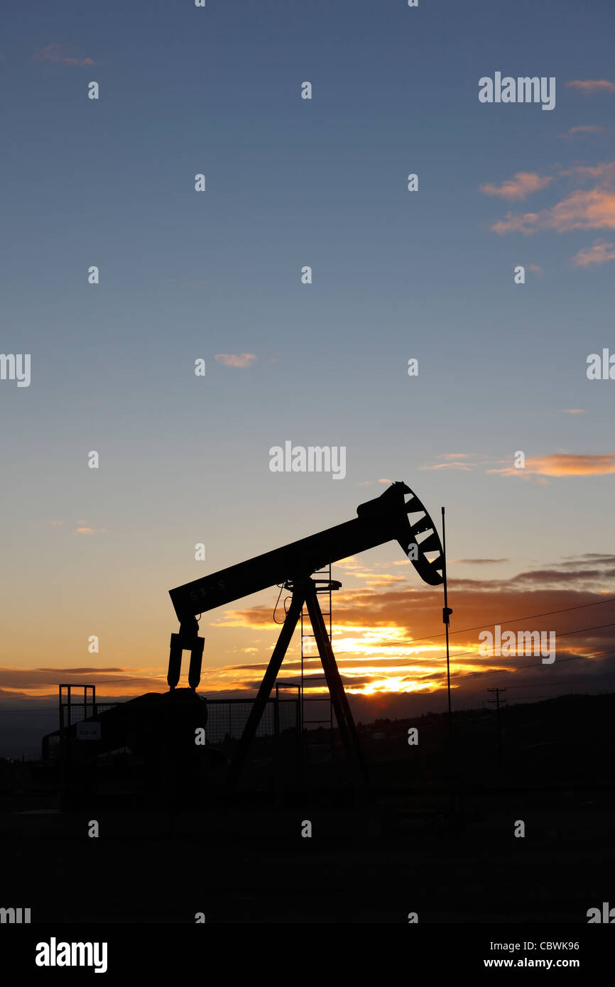Pompe à huile sur un puits de pétrole sur le champ pétrolifère de Midway-Sunset près de Taft, Californie à l'aube. Banque D'Images
