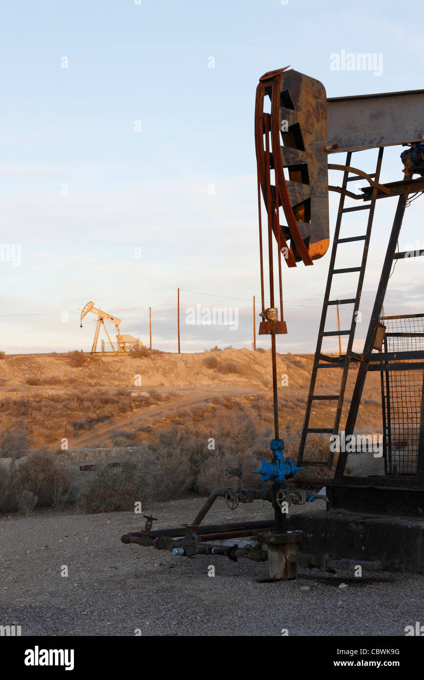 Pompe à huile sur un puits de pétrole sur le champ pétrolifère de Midway-Sunset près de Taft, Californie à l'aube. Banque D'Images