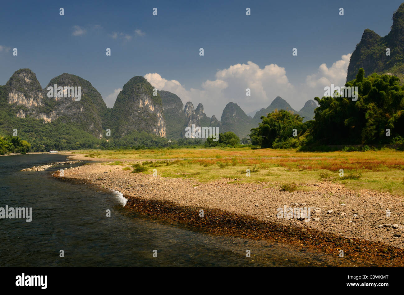 Rive de galets de la rivière Lijiang Li ou République populaire de Chine avec des cônes et les pics karstiques Banque D'Images